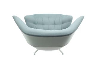 Lichtblauw gestoffeerde design fauteuil met ergonomische kuilen, opstaande zijarmen en wit pootenstelsel op witte achtergrond