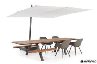 Houten vergadertafel met grijze poten, bijpassende banken, grijze stoelen en groot wit parasol op centrale staander.