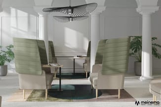 Loungehoeken met groene en beige stoelen, zwarte tafels, witte zuilen, designhanglamp en potplanten in kantoorruimte.