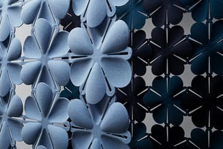 Akoestische panelen met bloemvormig motief in licht- en donkerblauw, uitgelijnd in rijen tegen neutrale achtergrond.