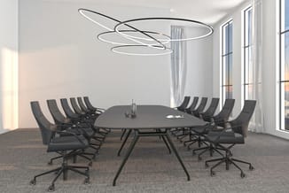 Moderne vergaderruimte met zwarte ovale tafel, zwarte ergonomische bureaustoelen op wielen, ronde LED-hanglamp en grote ramen