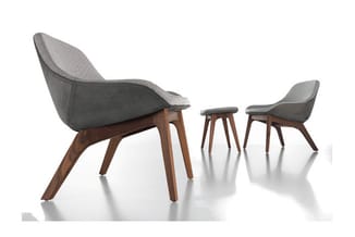 Grijze loungefauteuil en bijpassende stoel met houten poten, naast klein houten tafeltje op witte ondergrond.