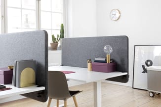 Moderne kantoorset met grijze akoestische schermen, wit bureau, taupe stoel, paarse opbergboxen en potplant bij raam.