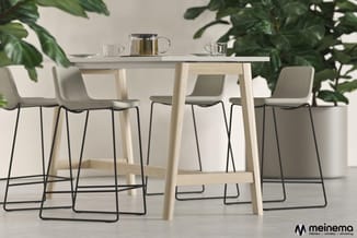 Hogebarset met licht houten tafelblad en poten, vier beige barkrukken met zwart metalen onderstel, theeset op tafel, omgeven