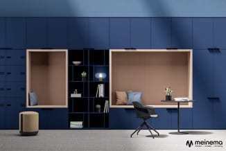 Moderne kantoorwerkplek met blauwe wandpanelen, twee bruine inbouwkasten, zwart stellingkastensysteem, beige poef, zwarte bur