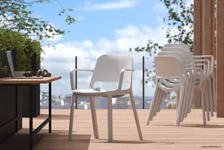 Witte kunststof stapelstoelen met armleuningen op houten terras met uitzicht op stad, naast werktafel.