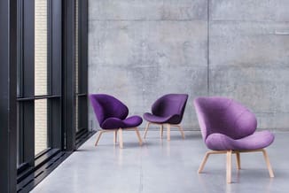 Drie paarse stoelen met organische vormen en houten poten in een moderne betonnen ruimte naast grote ramen.