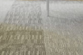 Grijsbeige tapijt met lijnpatroon en witte deurkozijn, bovenaanzicht kantoorinterieur