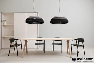 Moderne vergaderruimte met lichte houten tafel, zwarte stoelen, twee hangende zwarte dome-lampen en wandkast. Meinema-logo.