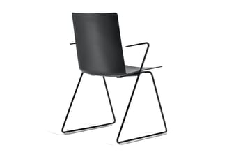 Zwarte kantoorstoel met gesloten rugleuning, metalen armleuningen en trapeziumvormig stalen frame op wit oppervlak.