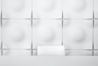 Witte gestoffeerde wandpanelen met subtiele textuur in een moderne kantooromgeving, voorzien van grijze afwerkingslijsten.