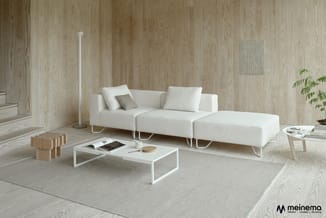 Moderne lounge met witte modulaire bank, witte salontafel, houten vloer en beige tapijt, aangevuld met houten accessoires en