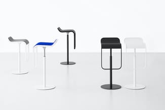 Zeven design barkrukken in verschillende kleuren en uitvoeringen (wit, zwart, blauw) met gebogen rugleuning, rondom zwart voe