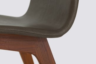 Grijze leren stoel met houten poten in walnootkleur, zijaanzicht met gestitchte naden.