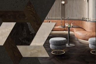 Moderne lounge met cognackleurige leren sofa, grijze poefjes met goudkleurige frame, zwarte salontafel, en houten wanddecorat