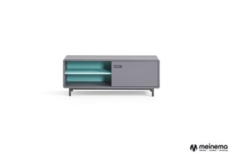 Grijze TV-kast met turquoise legplanken aan linkerzijde en gesloten schuifdeur rechts, op vier poten.