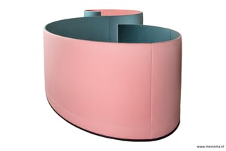 Roze gefabriceerde zitbank met teal-blauwe binnenzijde, curved vorm, zwart onderstel, compartimentering zichtbaar.