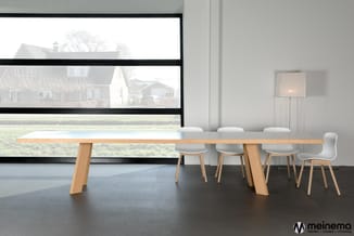 Moderne vergaderruimte met lange houten tafel, witte stoelen en grote raampartijen met uitzicht op landelijk gebied.