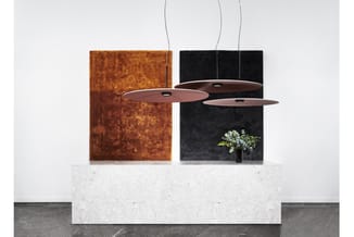 Showroom opstelling met drie hangende lampen in roestbruin en zwart, witte marmeren tafelblad, roestbruine en zwarte akoestis