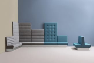 Modulaire zitlandschap in grijs en turquoise met gechetteerde rugleuningen, enkele loungestoelen, tegen blauwe en beige muurv