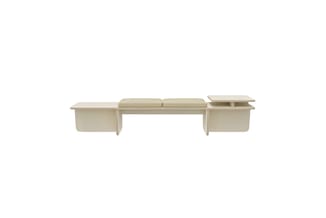 Beige modulaire bank met twee zitblokken in het midden, armleuningen aan beide zijden en kussens bovenop, tegen witte achterg