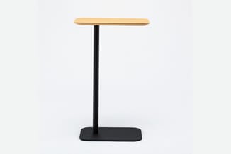 Staande tafel met rechthoekig houten blad in natuurtoon en zwart metalen onderstel met vierkante voetplaat.