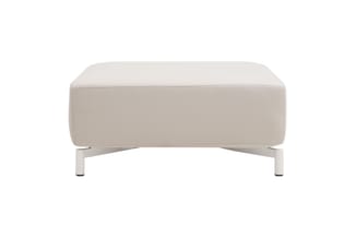 Beige/crème poef of voetenbankje met afgeronde hoeken en witte poten, frontaanzicht op witte achtergrond.