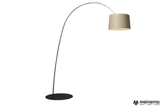 Zwarte boogvloerlamp met beige linnen lampenkap tegen witte achtergrond.