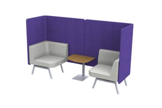 Paarse akoestische wanden met twee grijze fauteuils en houten bijzettafel, gecreëerde afgesloten zithoek.