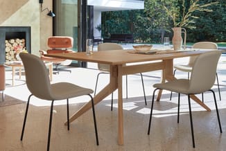 Houten vergadertafel met beige stoelen met zwart metalen frame in moderne kantoorruimte met ramen en uitzicht op terras.