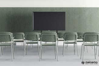 Rij grijsgroene stoelen met metalen frames in vergaderruimte met groen gestreepte wand en zwart scherm.