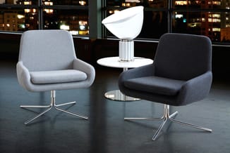 Twee moderne draaifauteuils in licht- en donkergrijs stof met metalen voetstuk, rond bijzettafeltje met witte lamp tussen, vo