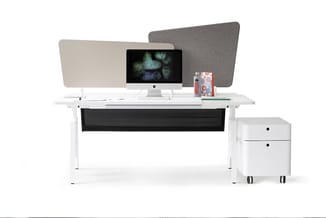 Witte bureau met zwarte kabelgoot, twee grijze akoestische schermen, iMac-monitor, rode objecten en witte ladeblok op wielen.