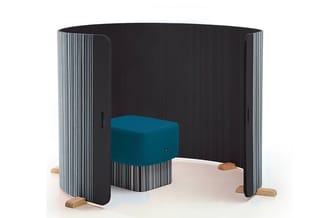 Akoestische afscherming met verticale latten in zwart en wit, houten voetjes, met turquoise zitpoef binnen de ruimte.