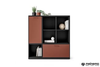 Zwart-bruine modulaire boekenkast met open vakken, gesloten deuren en decoratieve items zoals planten, boeken en accessoires.