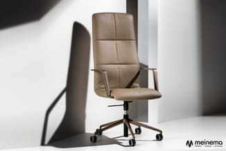 Beige leren bureaustoel met hoge rugleuning, armleuningen en zwart onderstel met wieltjes in minimalistisch interieur.