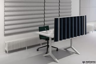 Werkplek met wit bureau, zwarte bureaustoel, zwart akoestisch scherm, grijze en witte wandpanelen, witte radiator en roldak.