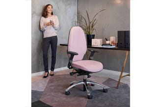 Roze bureaustoel met ergonomische rugleuning en zwarte armleuningen in modern kantoor met grijze muren, donker bureau en potp