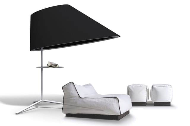Moderne loungehoek met witte gestoffeerde zitbank, twee witte kubusvormige poefs, grijze driepoot staande lamp met groot zwar