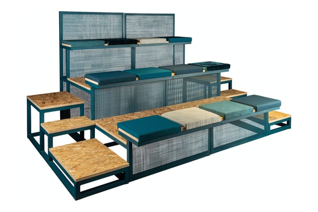 Modulair kantoormeubelsysteem met teakkleurige houten zitelementen, turquoise metalen frame en gazen scheidingswanden.