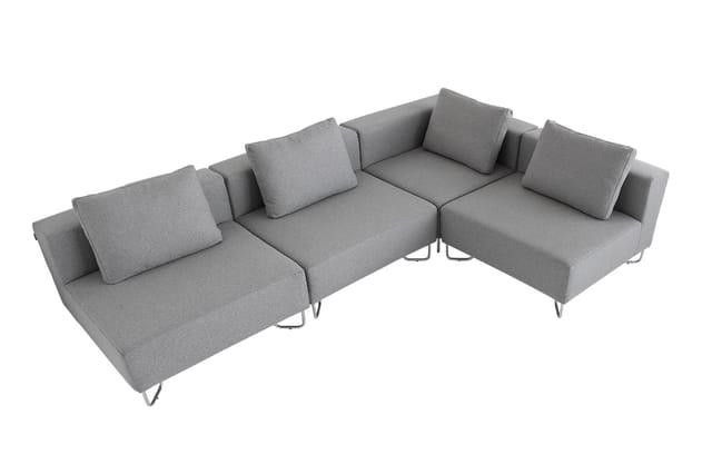 Grijze modulaire bank met hoekopstelling, losse kussens en metalen poten op witte achtergrond.