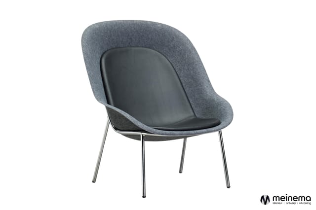 Grijze loungefauteuil met zwart zitgedeelte, gebogende rugleuning en chromen poten, vrijstaand tegen witte achtergrond.