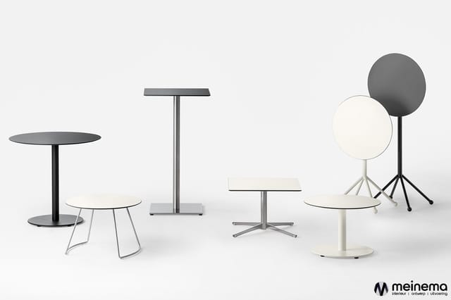Collectie minimalistisch tafelwerk: ronde zwarte tafel met witte stoel, rechthoekige tafel met staanders, en witte tafels met