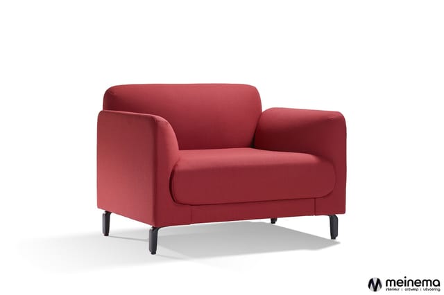 Rode fauteuil met afgeronde vormen, gestoffeerd zitgedeelte, zwarte poten, staande tegen witte achtergrond.