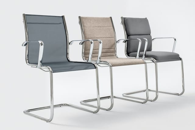 Drie kantooorstoelen met chromen frame en armleuningen, in grijs, beige en donkergrijs, op een rij tegen witte achtergrond.