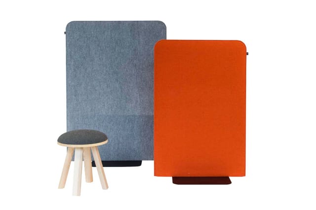 Akoestische panelen in blauwgrijs en oranje met houten kruk met grijze zitting.
