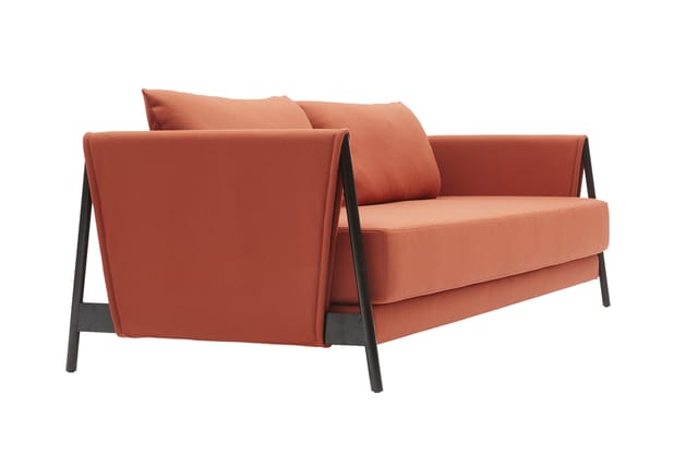 Oranje-rood loungebank met donkergrijze houten frame, armleuningen en ronde kussens tegen witte achtergrond.