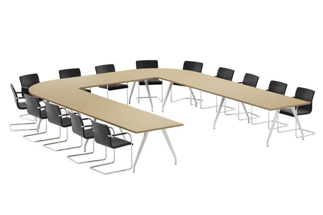 U-vormige vergadertafel met licht houtfineer blad en wit frame, omgeven door zwarte kantinestoelen op sledeframe.