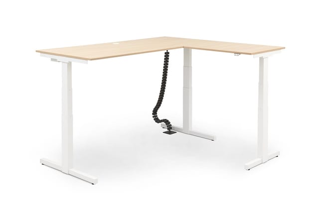 L-vormig elektrisch zit-sta bureau met houten blad en wit metalen onderstel, inclusief zwarte kabelgoot.