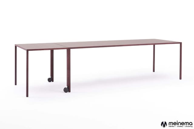 Lange vergadertafel met donkerrode houten frame en twee verrijdbare middensteunpoten, geschikt voor grote groepen.